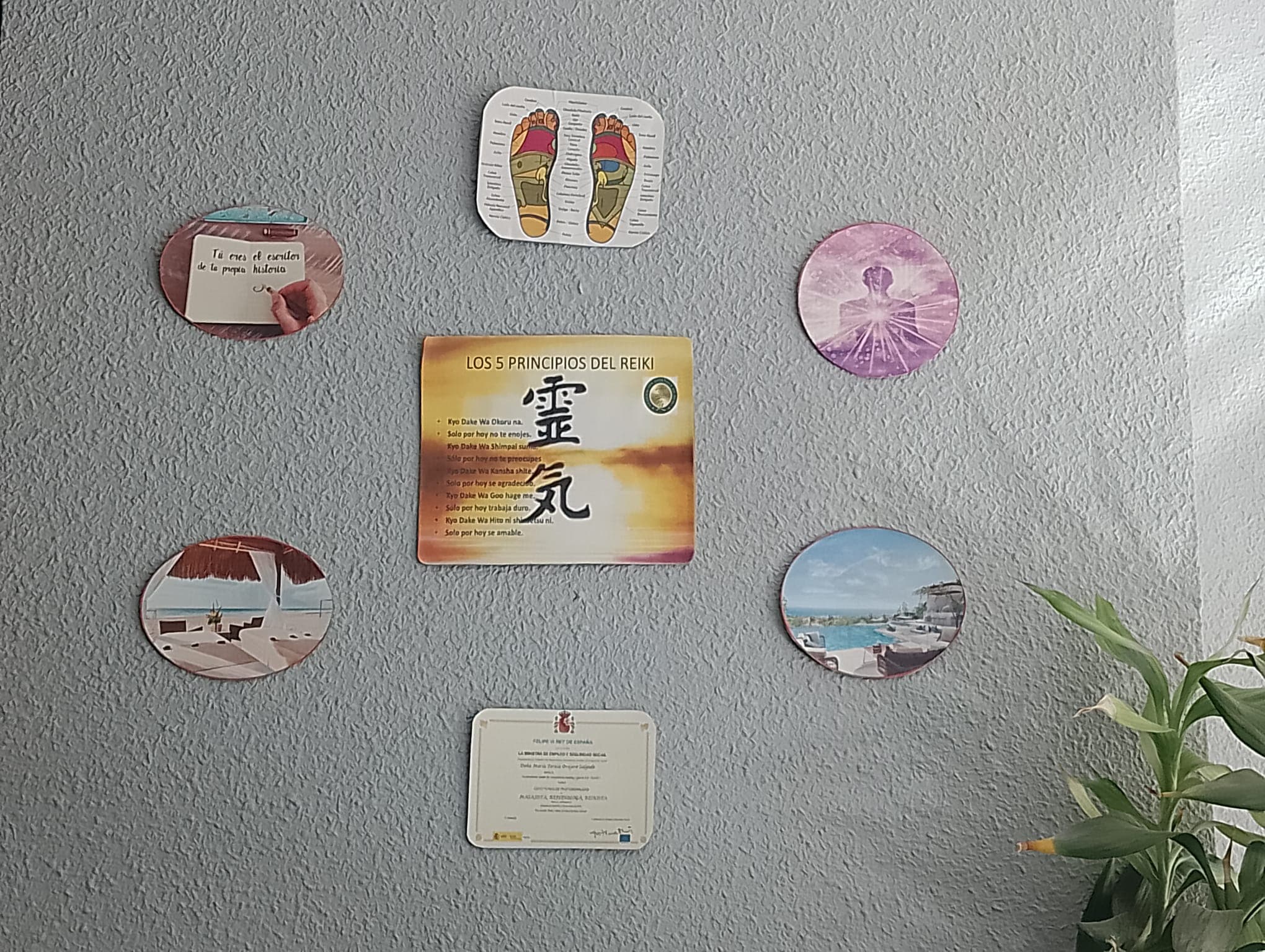 Pared de la consulta con los 5 Principios del Reiki, mapa de reflexología podal y certificación