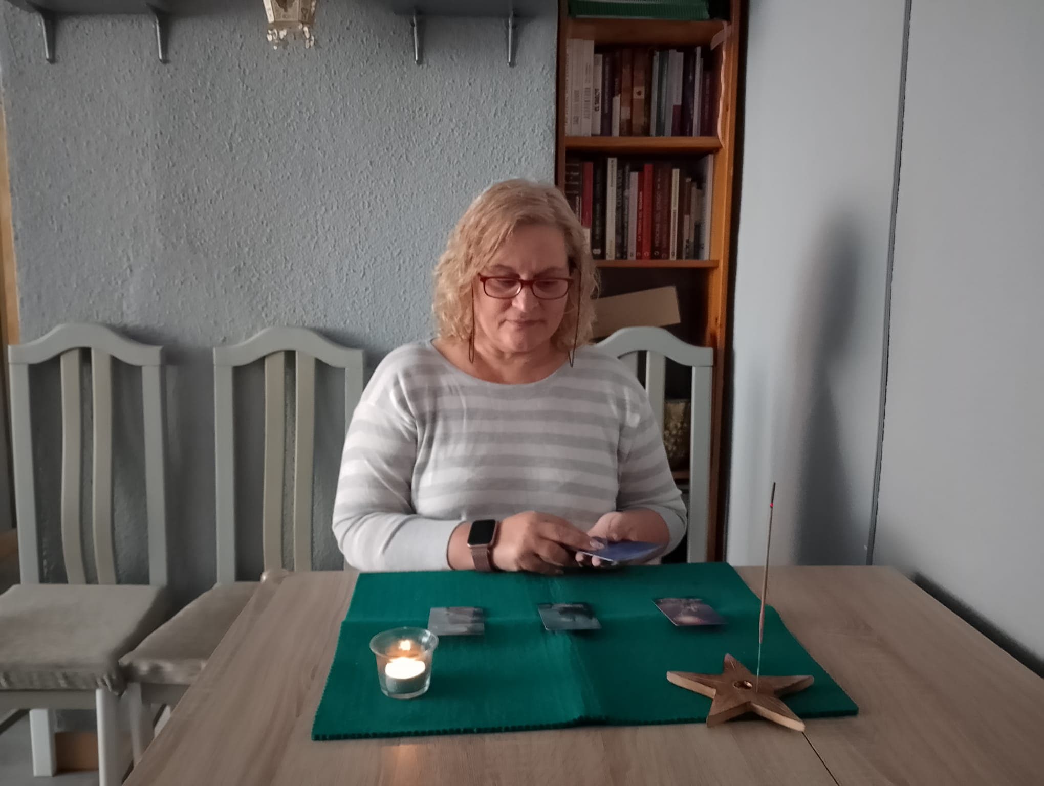 Mesa de trabajo con cartas de tarot, vela y estrella de madera para sesiones de guía y lectura